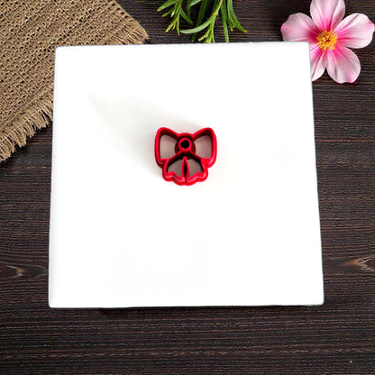 Red bow cookie-style cutter on white tile with flowers