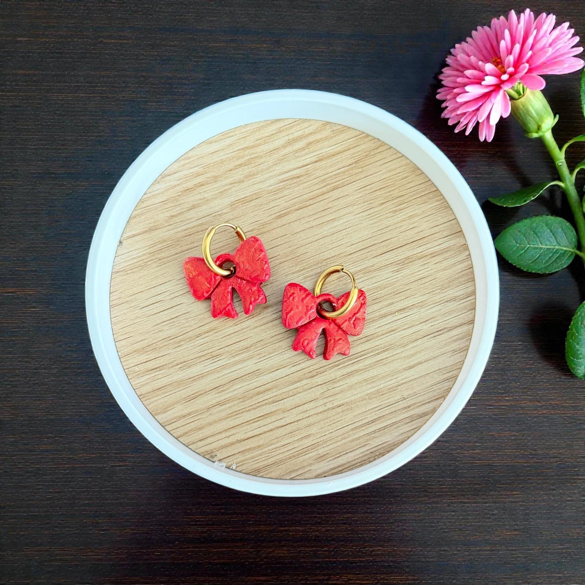 Red bow clay charms with gold hoops in round dish