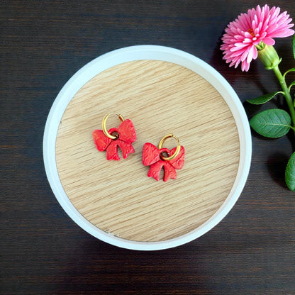 Red bow clay charms with gold hoops in round dish