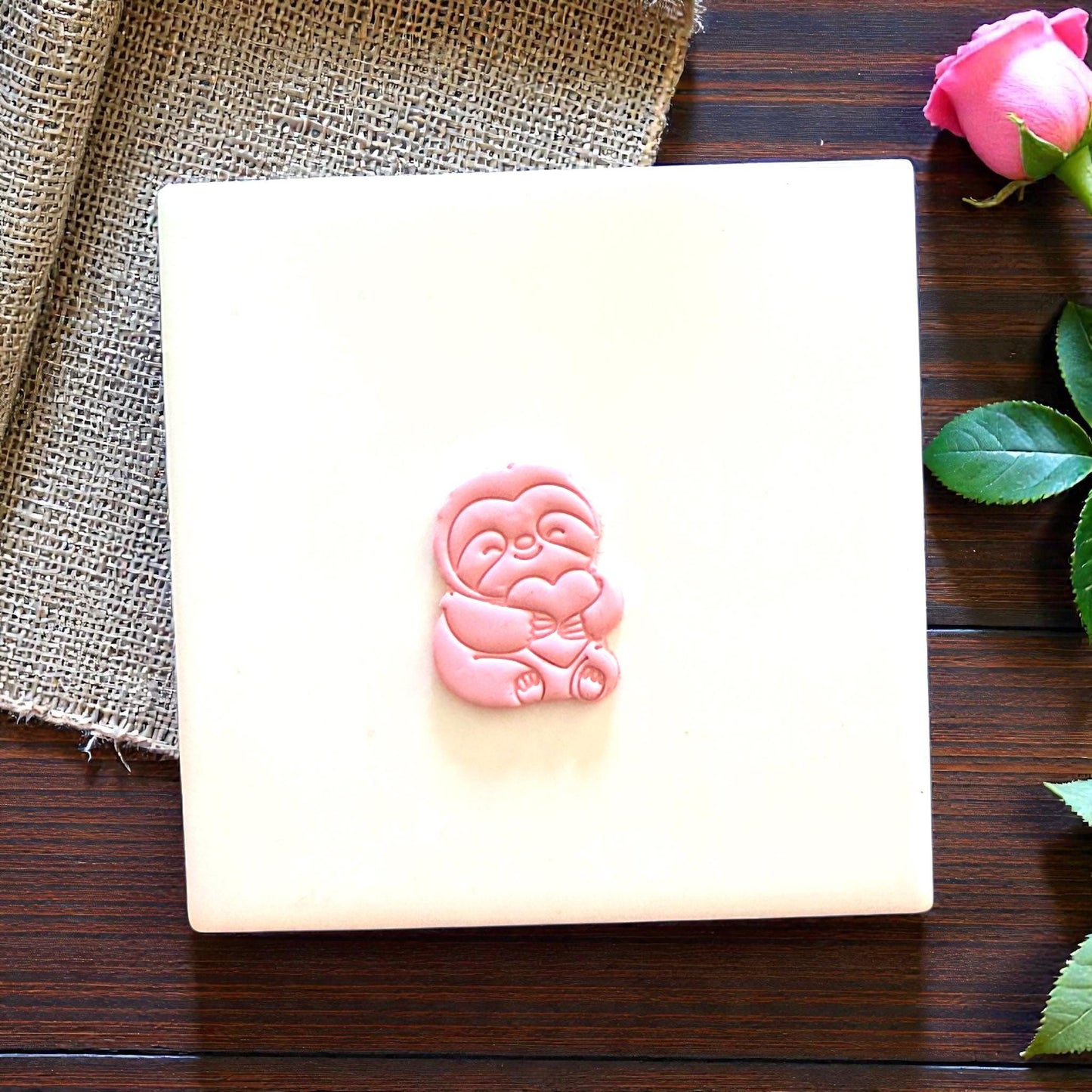 small sloth clay shape displayed on white tile