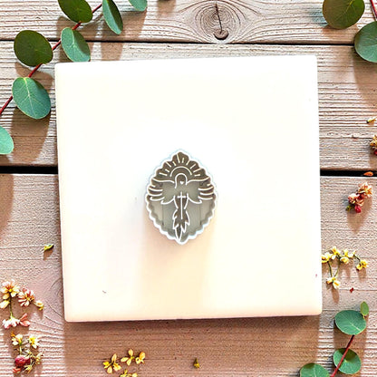 Square clay slab with dove and cross imprint on display