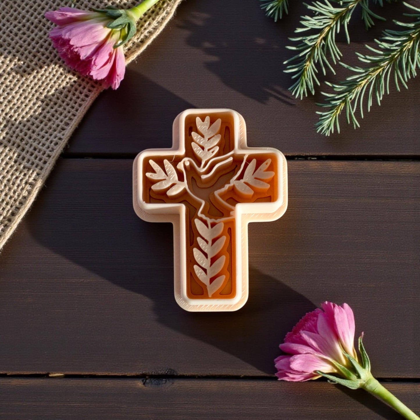 cross cutter with dove and leaf design on wood backdrop