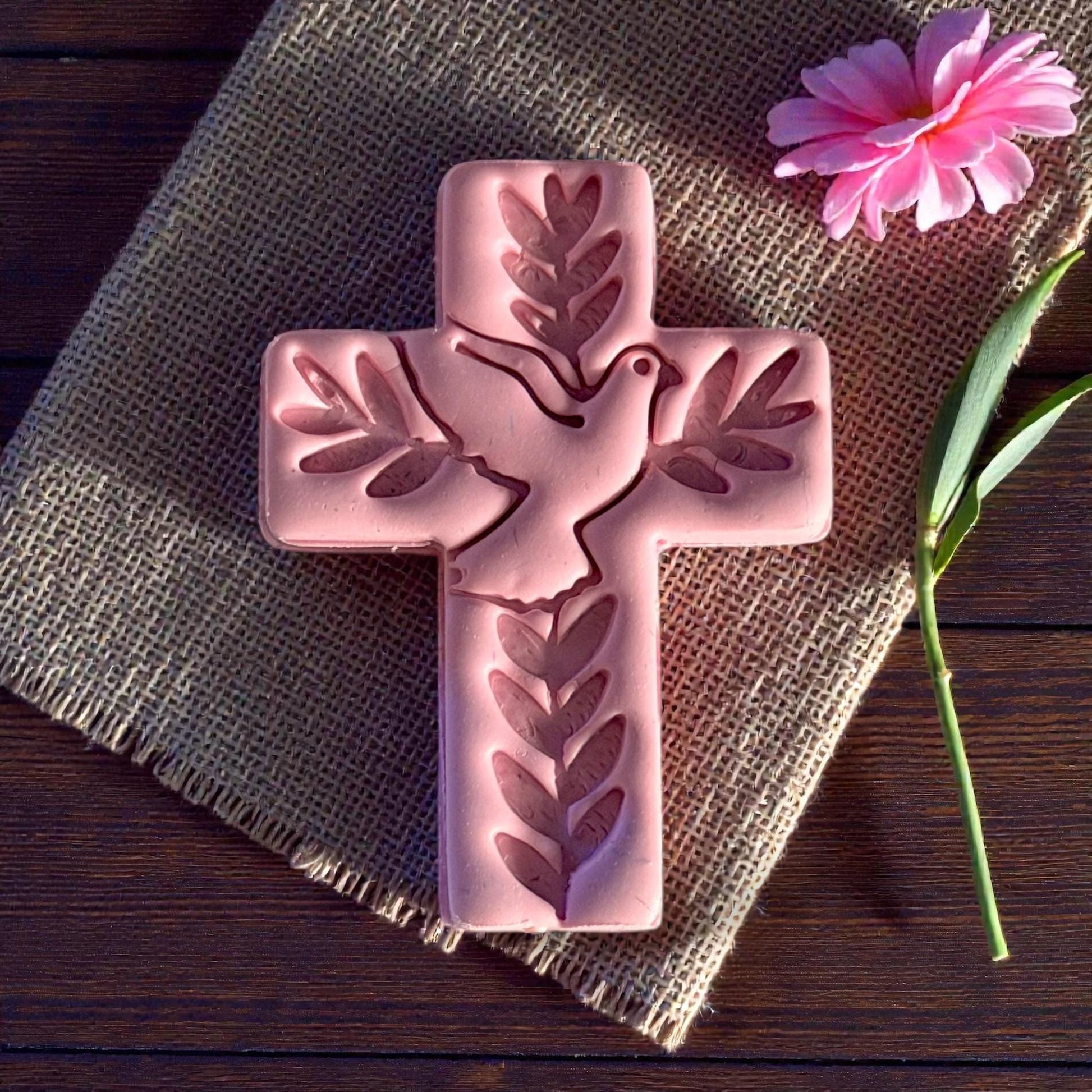 closeup pink clay cross with dove and leaf details