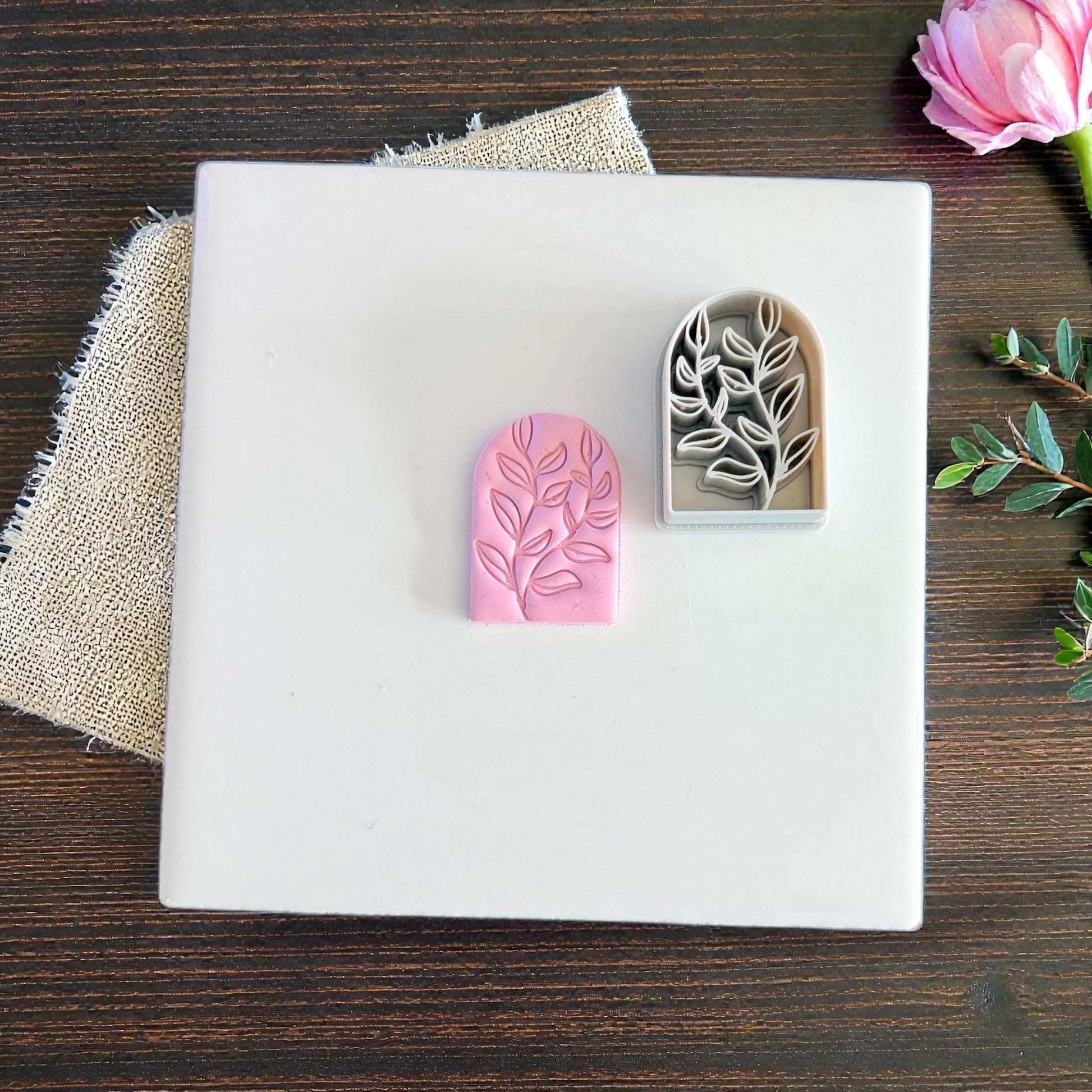 pink clay arch and gray cutter on white tile