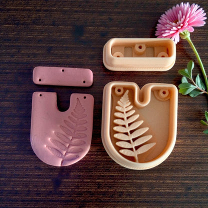 Cutter set next to clay impressions showing fern detail