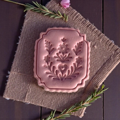close up of large folk floral clay plaque with scalloped frame