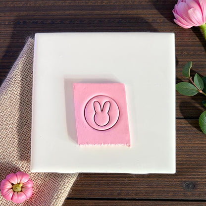 pink clay impression of bunny silhouette on white tile
