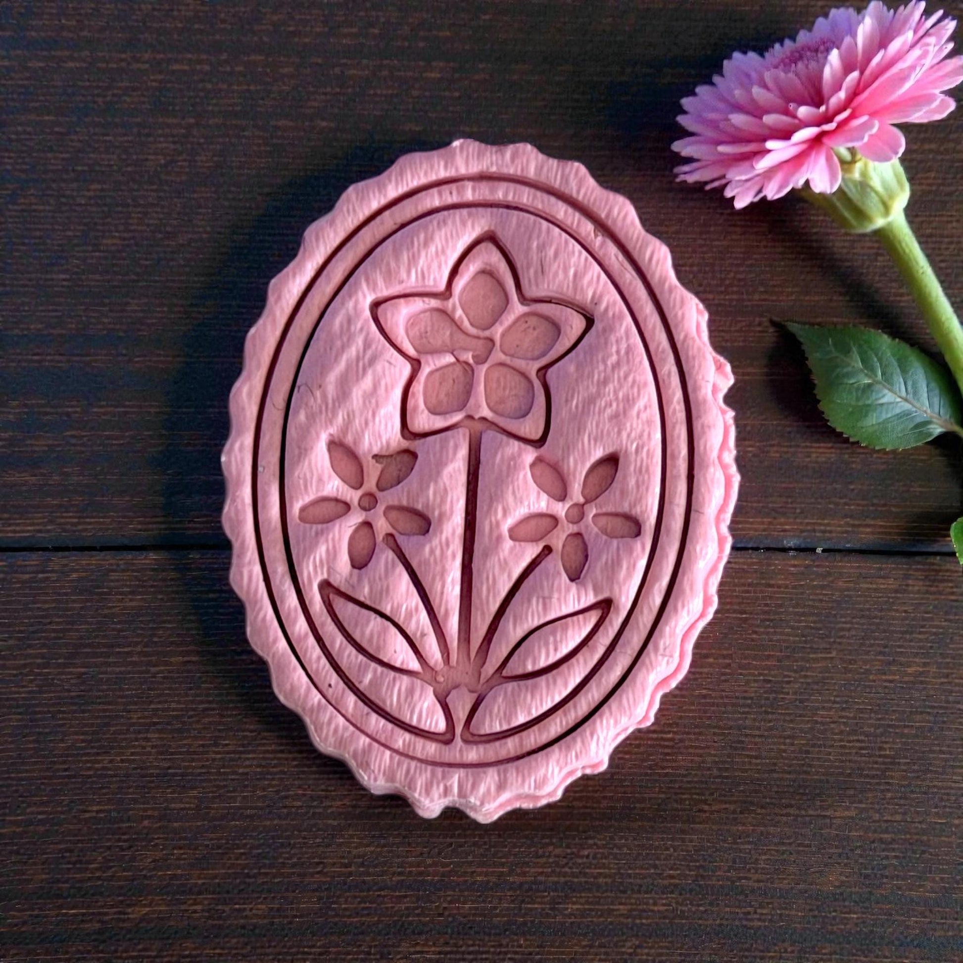 close-up oval floral cameo clay piece with scalloped edge