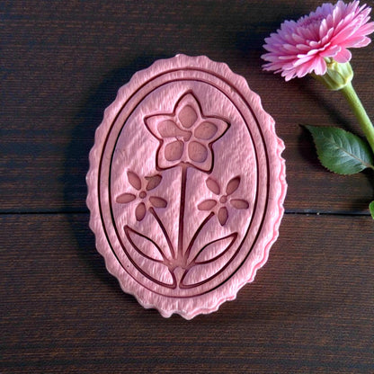 close-up oval floral cameo clay piece with scalloped edge