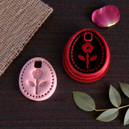 floral oval cutter and charm together on dark wood