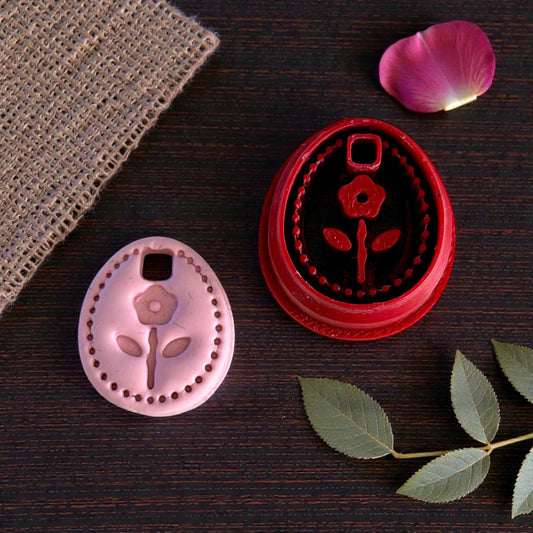 floral oval cutter and charm together on dark wood