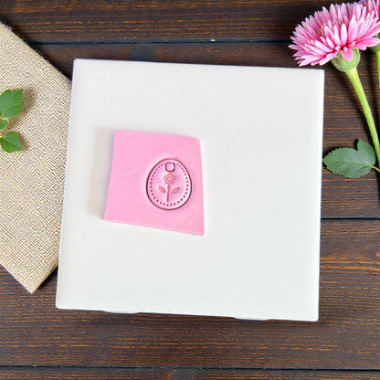 small floral oval clay charm impression on pink clay