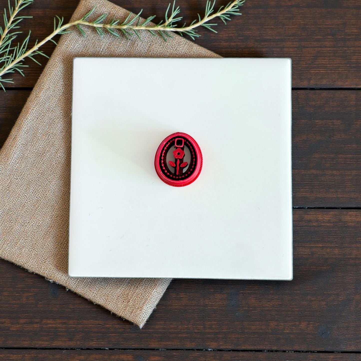 small red floral oval cutter centered on tile