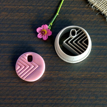 pink charm next to circle cutter with arrow design