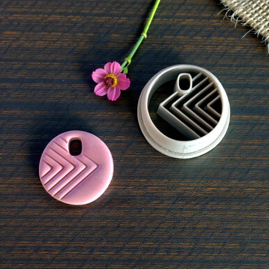 pink charm next to circle cutter with arrow design