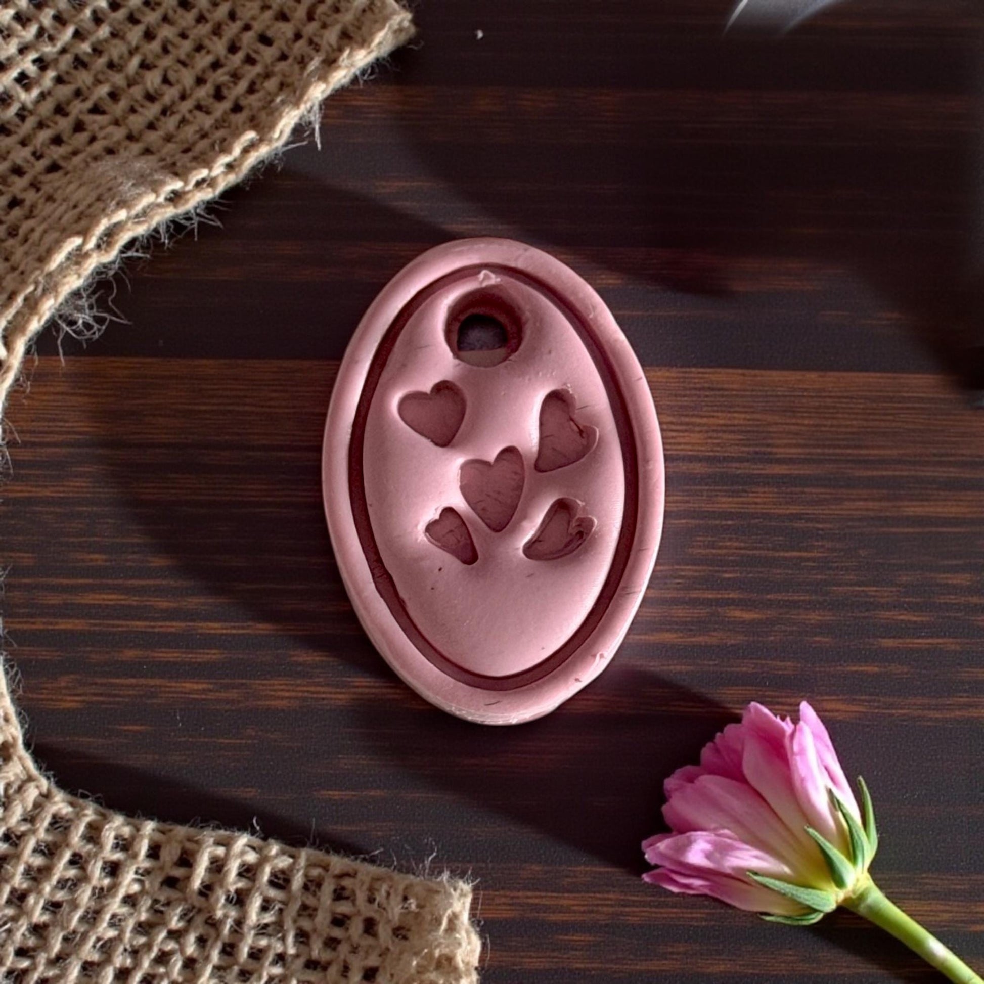 close up of pink oval heart charm impression