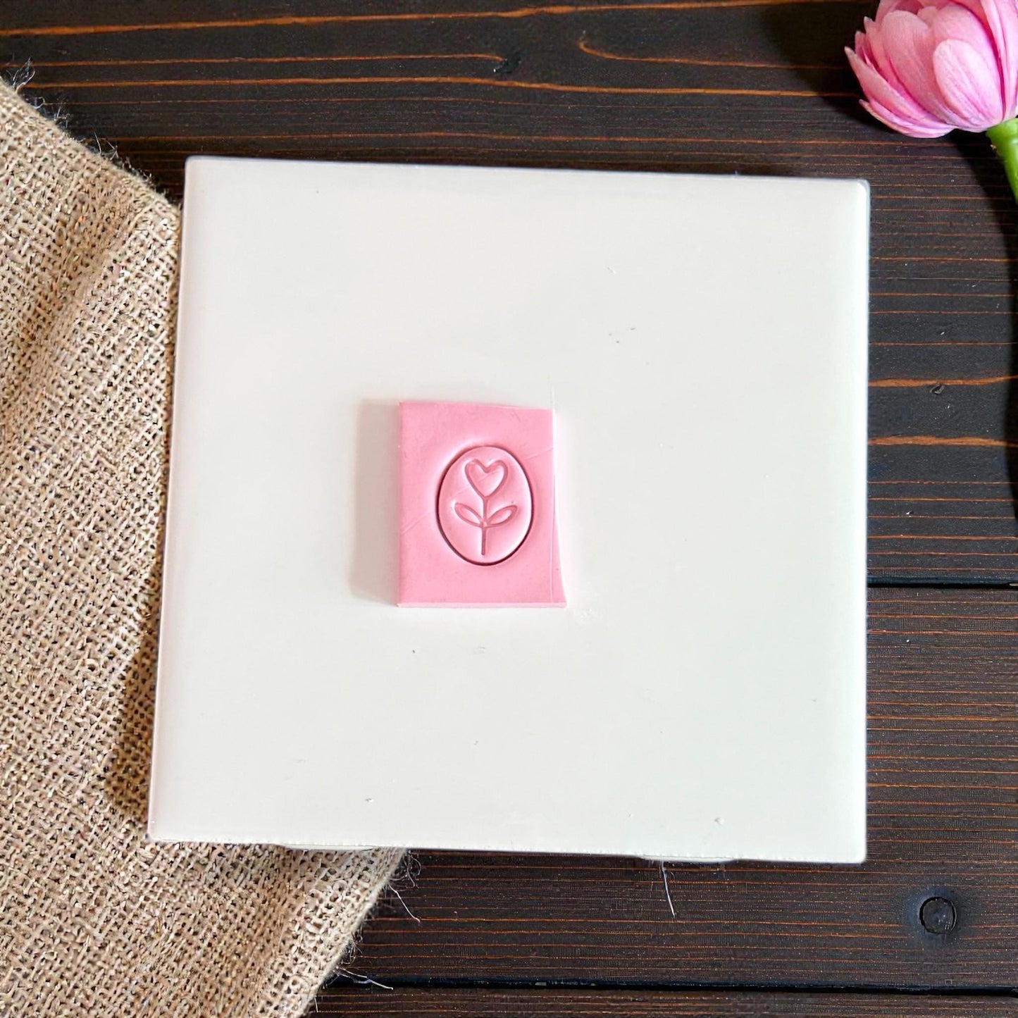 heart flower oval charm cutter pressed in pink clay on tile
