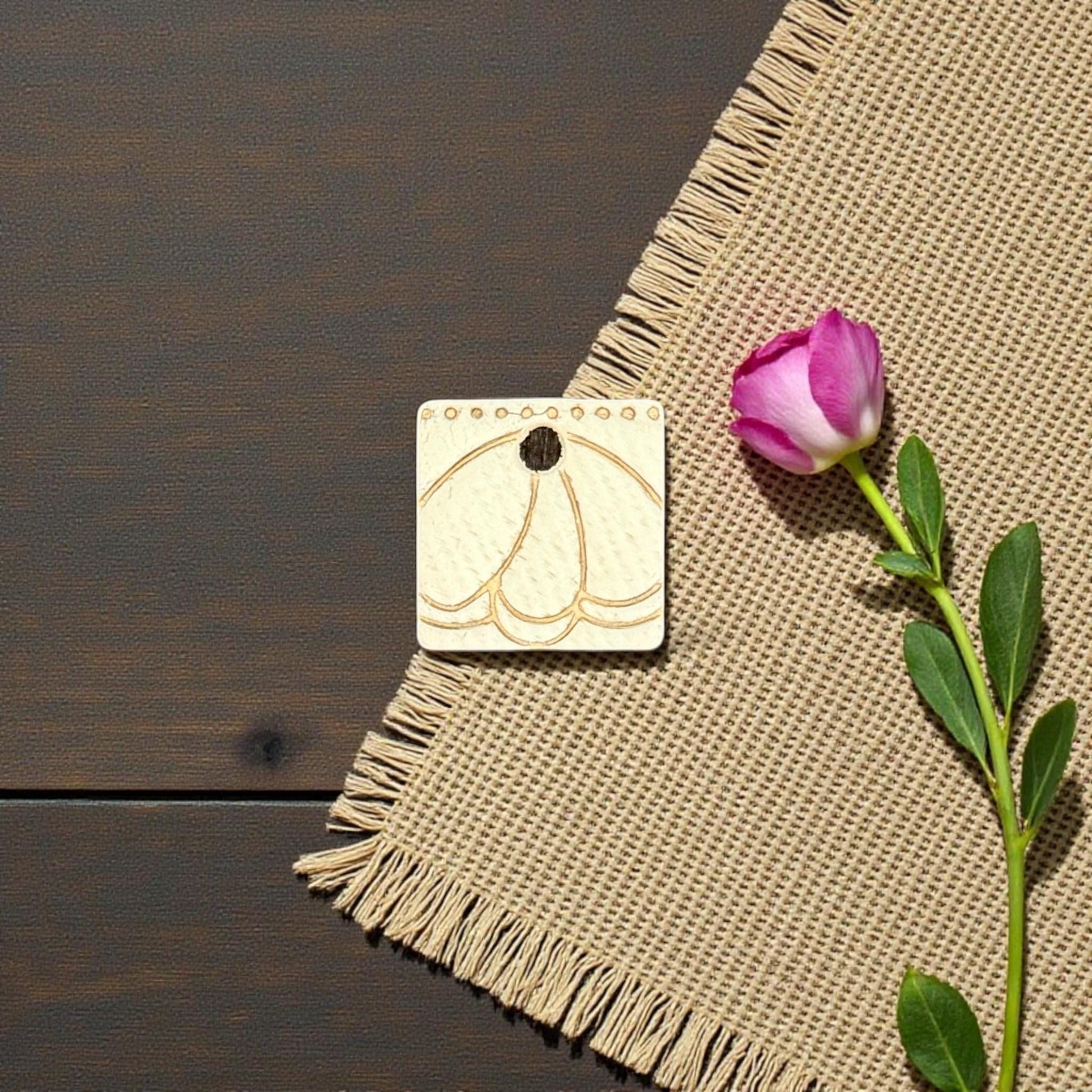 engraved metal charm with scalloped petal arch
