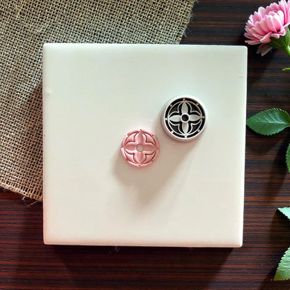 round floral clay cutter and pink clay impression side by side