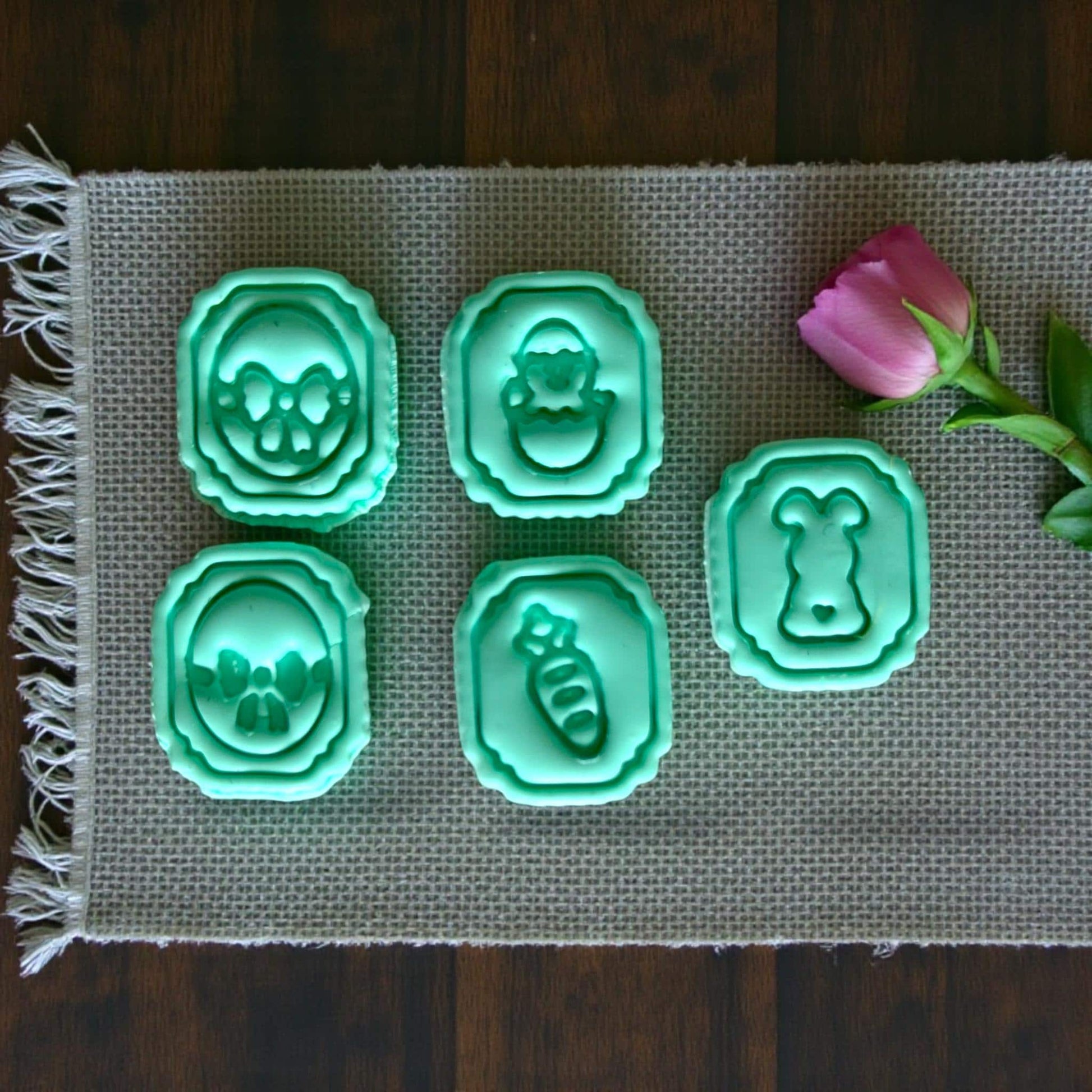 closeup of five Easter charm cutters on burlap mat