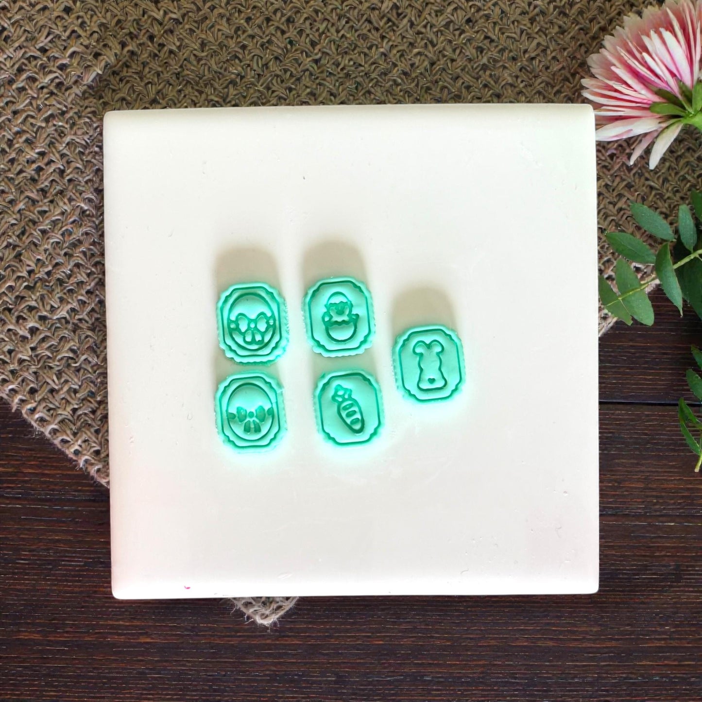 five mini Easter clay charms displayed on white tile