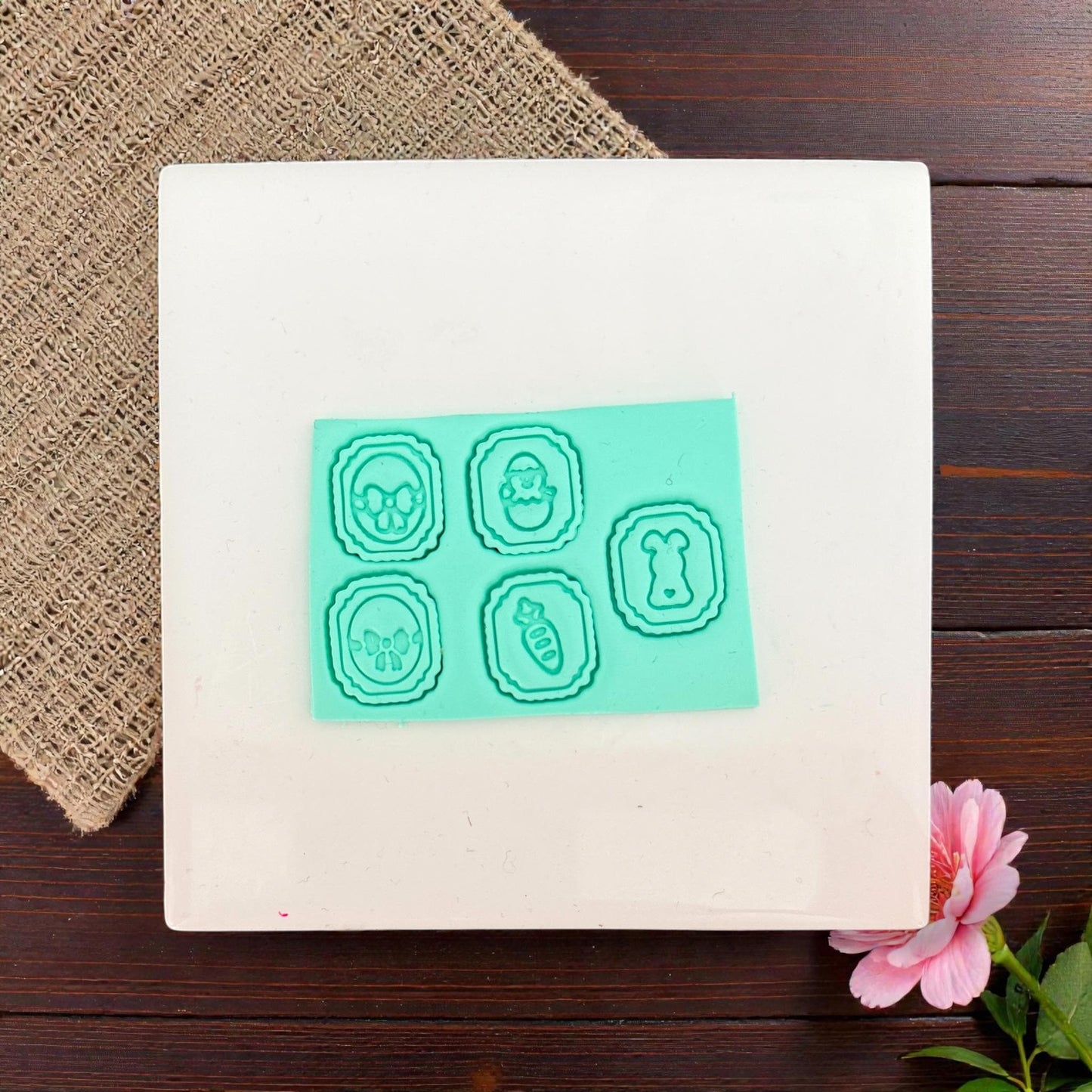 five mini Easter clay charms displayed on white tile