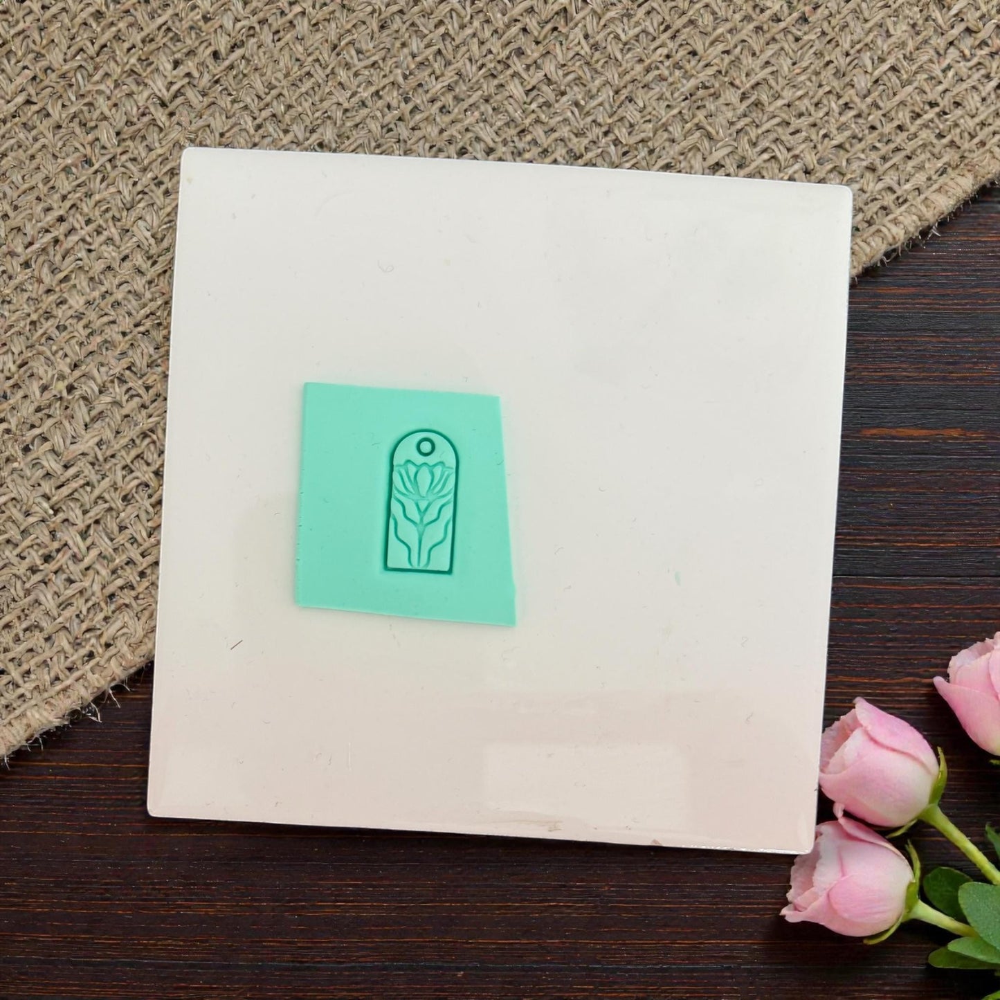 Floral charm impression pressed into clay