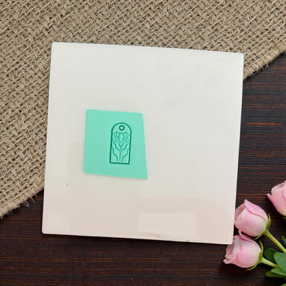 Floral charm impression pressed into clay