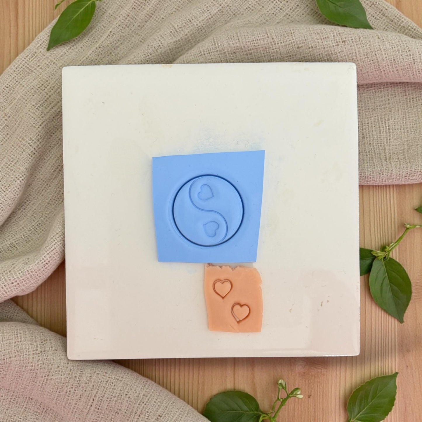 yin yang clay impression next to tiny heart impressions