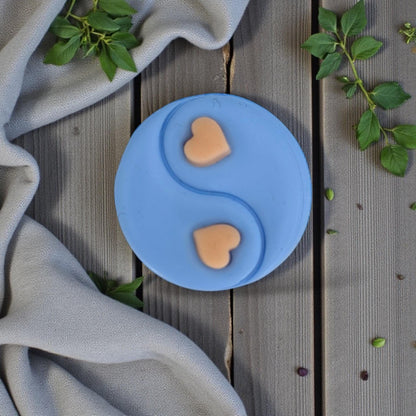 centered blue yin yang heart clay piece with greenery