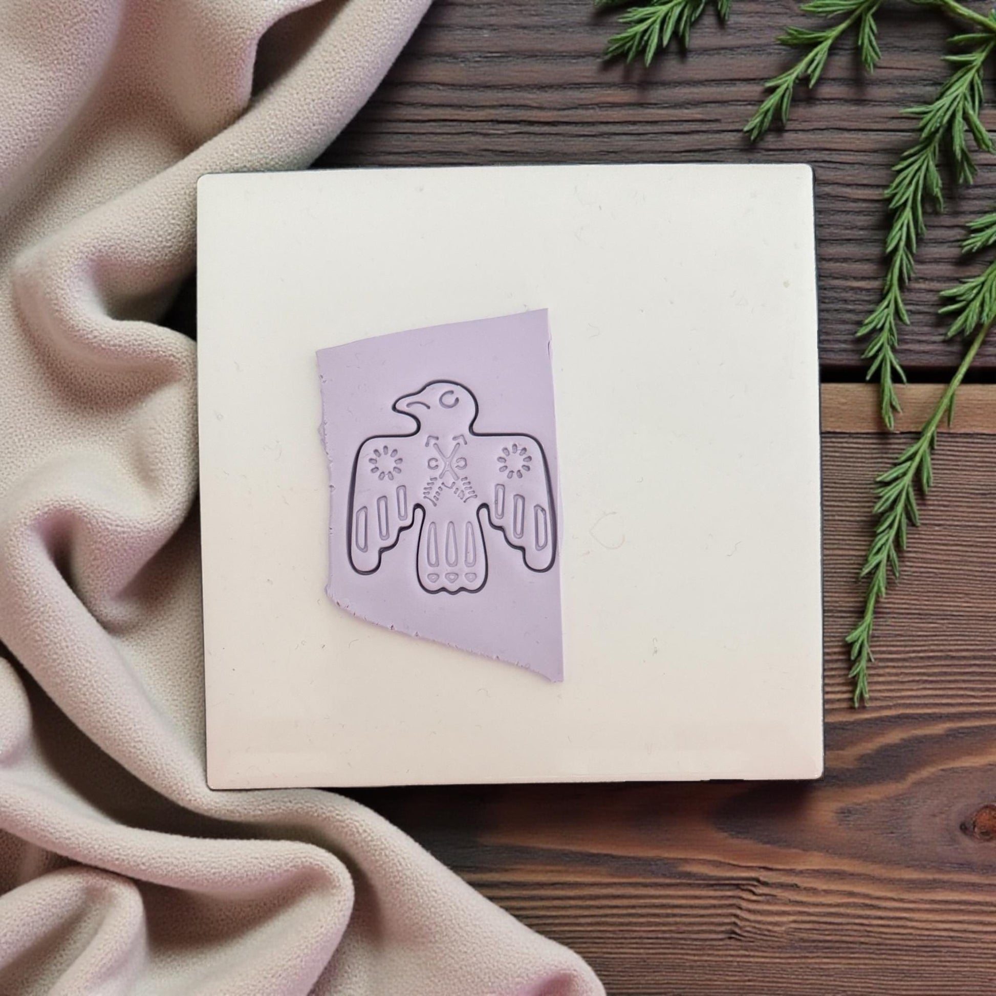 small lavender folk bird clay imprint on white tile