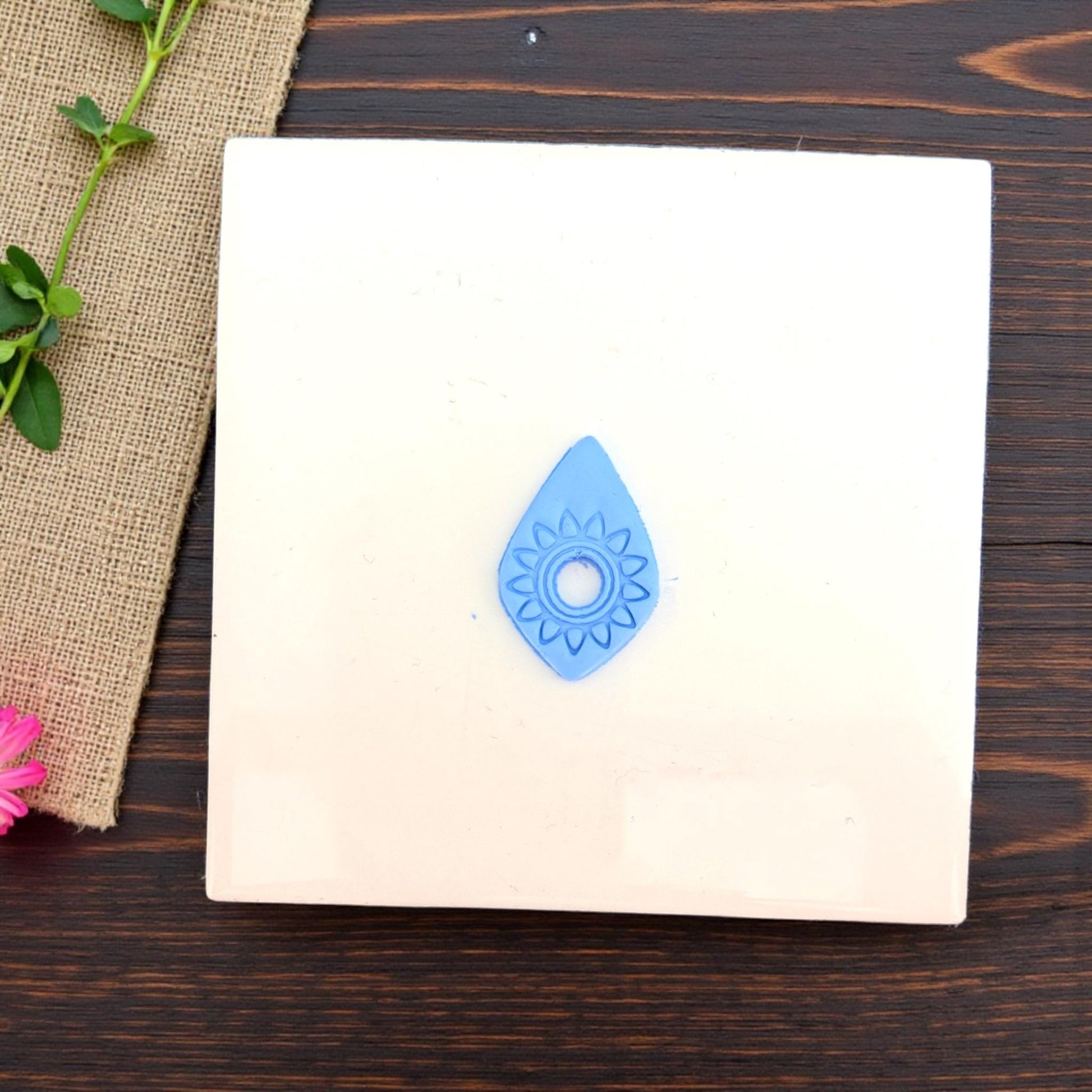 small blue sunburst impression centered on white tile