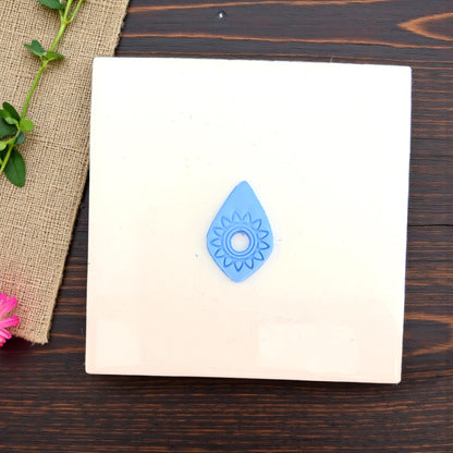 small blue sunburst impression centered on white tile