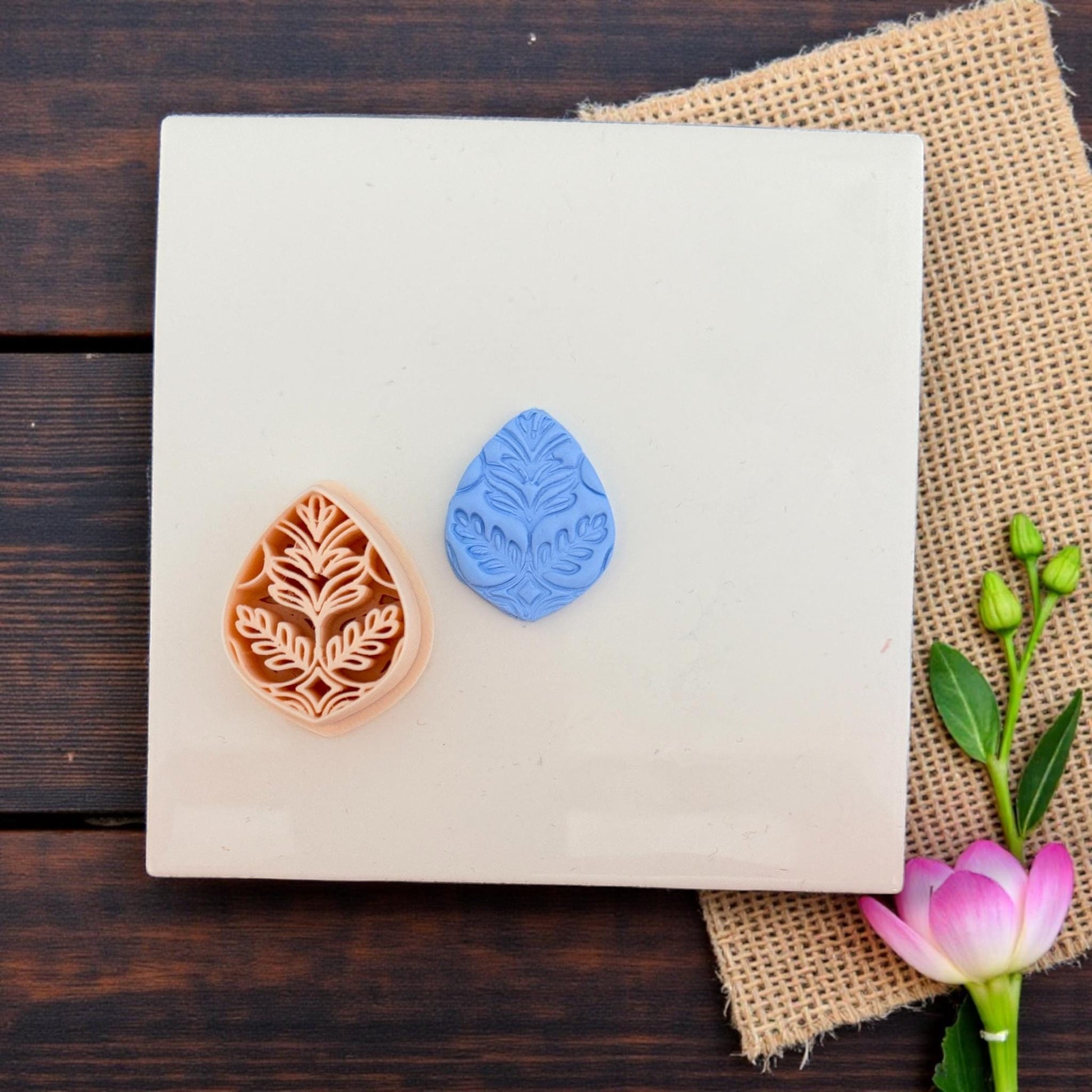 Polymer clay cutter with matching blue leaf imprint shown side by side