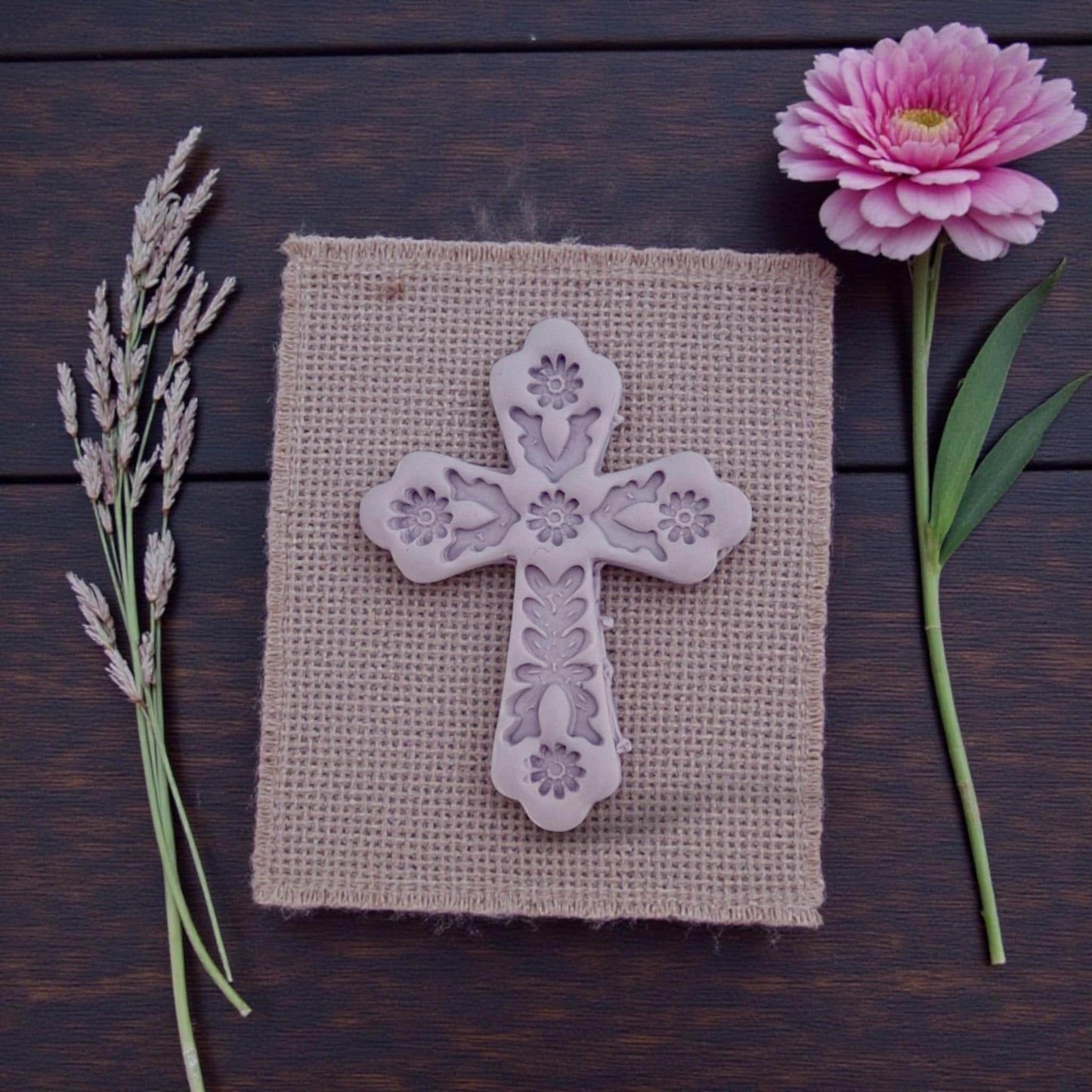 embossed floral cross clay piece on textured cloth