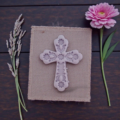 embossed floral cross clay piece on textured cloth