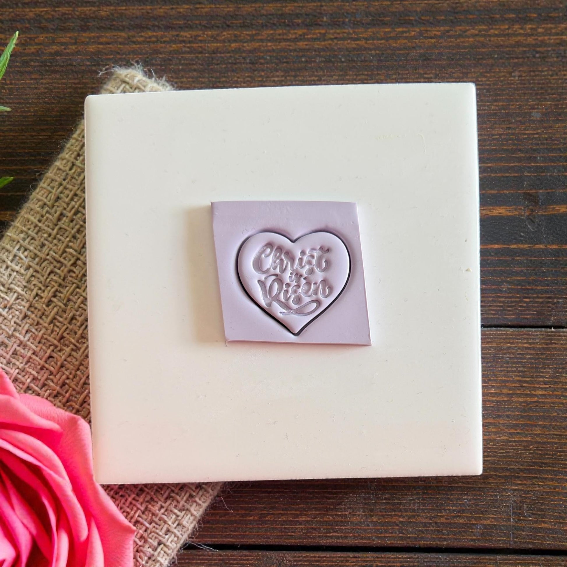 Purple heart clay impression cut in square on white tile