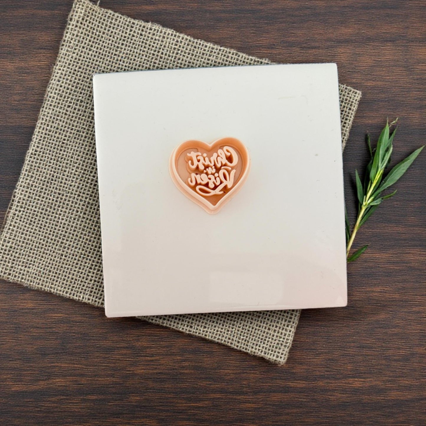Heart cutter on white tile with burlap