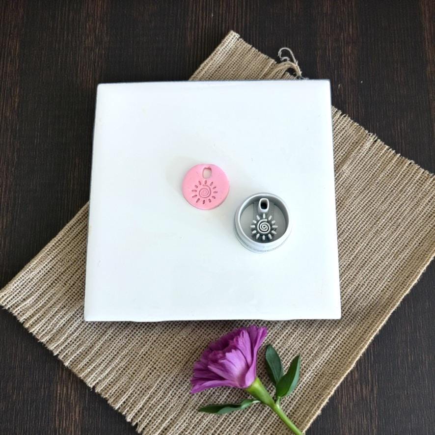 Pink charm and cutter displayed on white tile