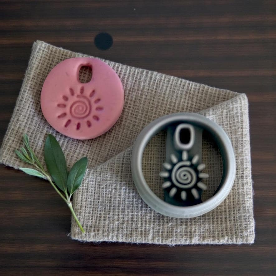 Charm and cutter shown together on textured cloth