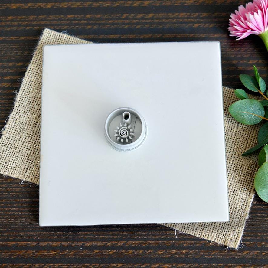 Cutter on white tile with pink flower