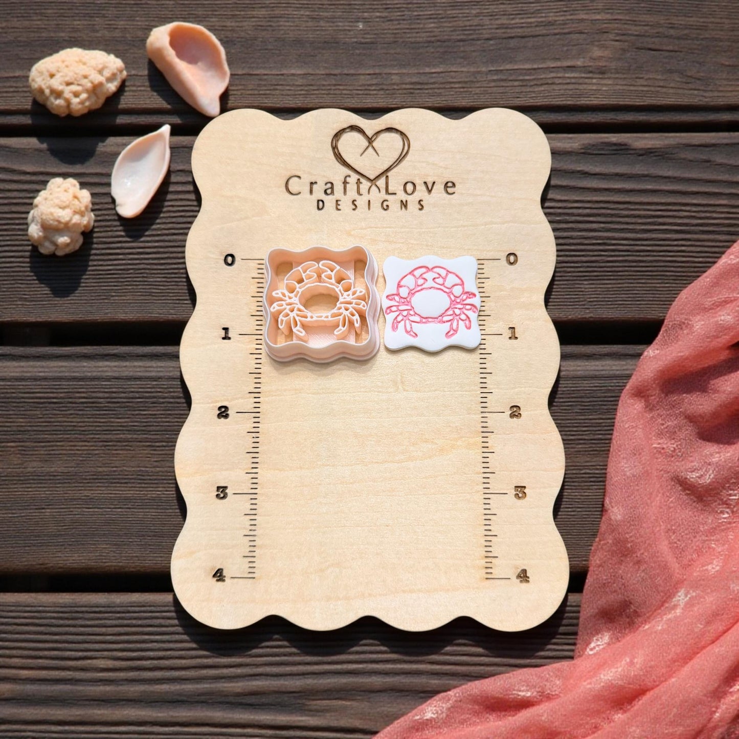 scalloped crab cutter and imprint on wooden size board with shells