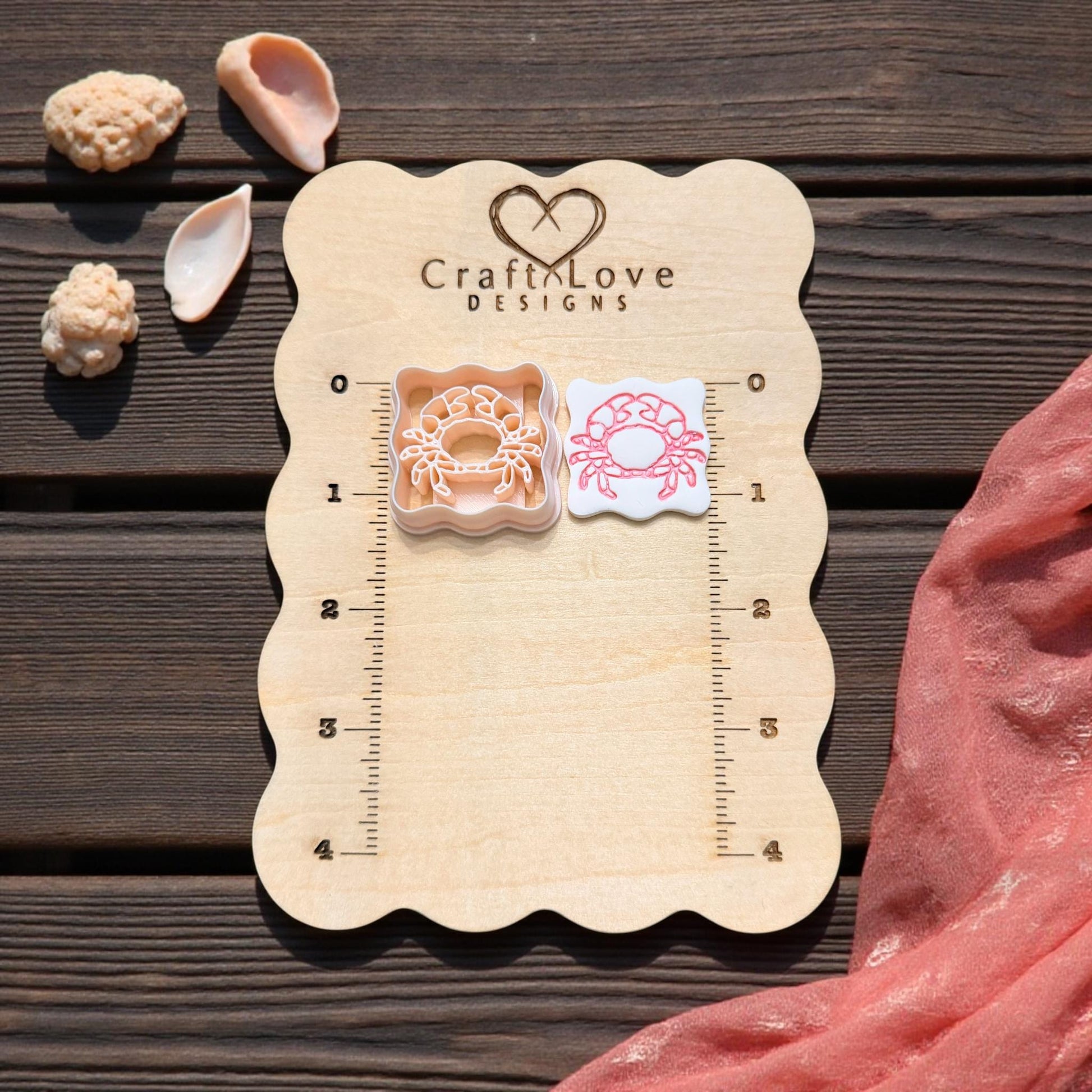 scalloped crab cutter and imprint on wooden size board with shells