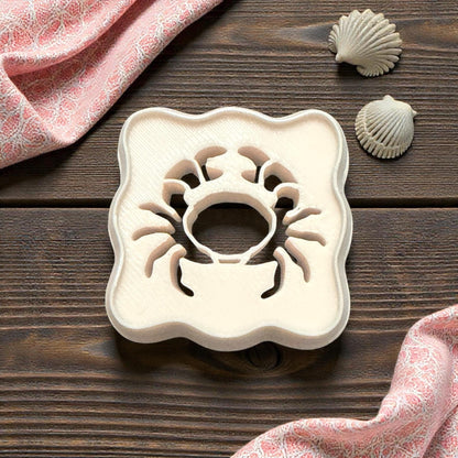 scalloped crab cutter on wooden background with shells and pink cloth