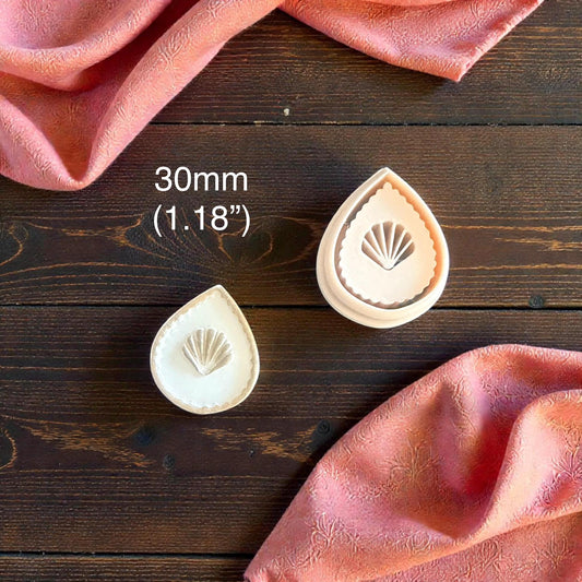 two teardrop seashell clay imprints with size label