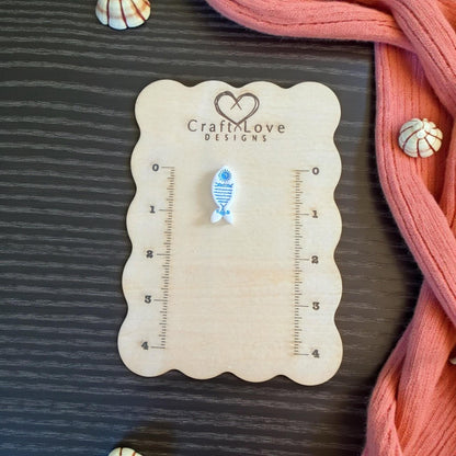 blue sun fish imprint on wood panel with shells