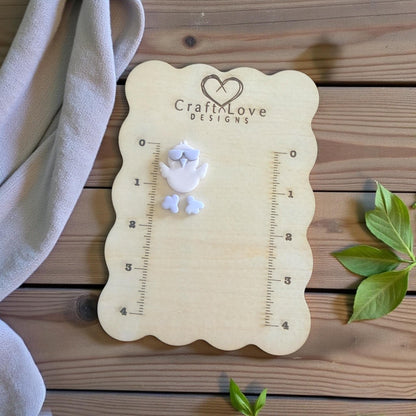 chick with feet on sizing board