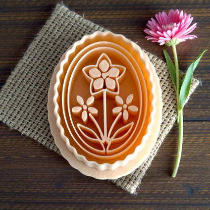 tan floral cameo cutter shown on burlap with flower