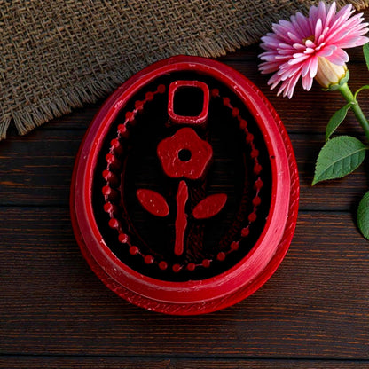red floral oval clay cutter on wood background