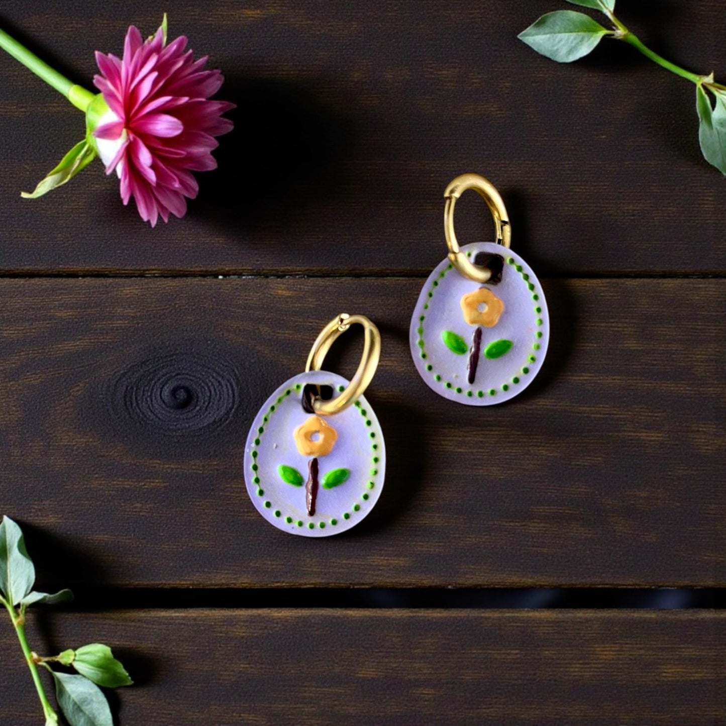 pair of floral oval charms on earrings in round tray